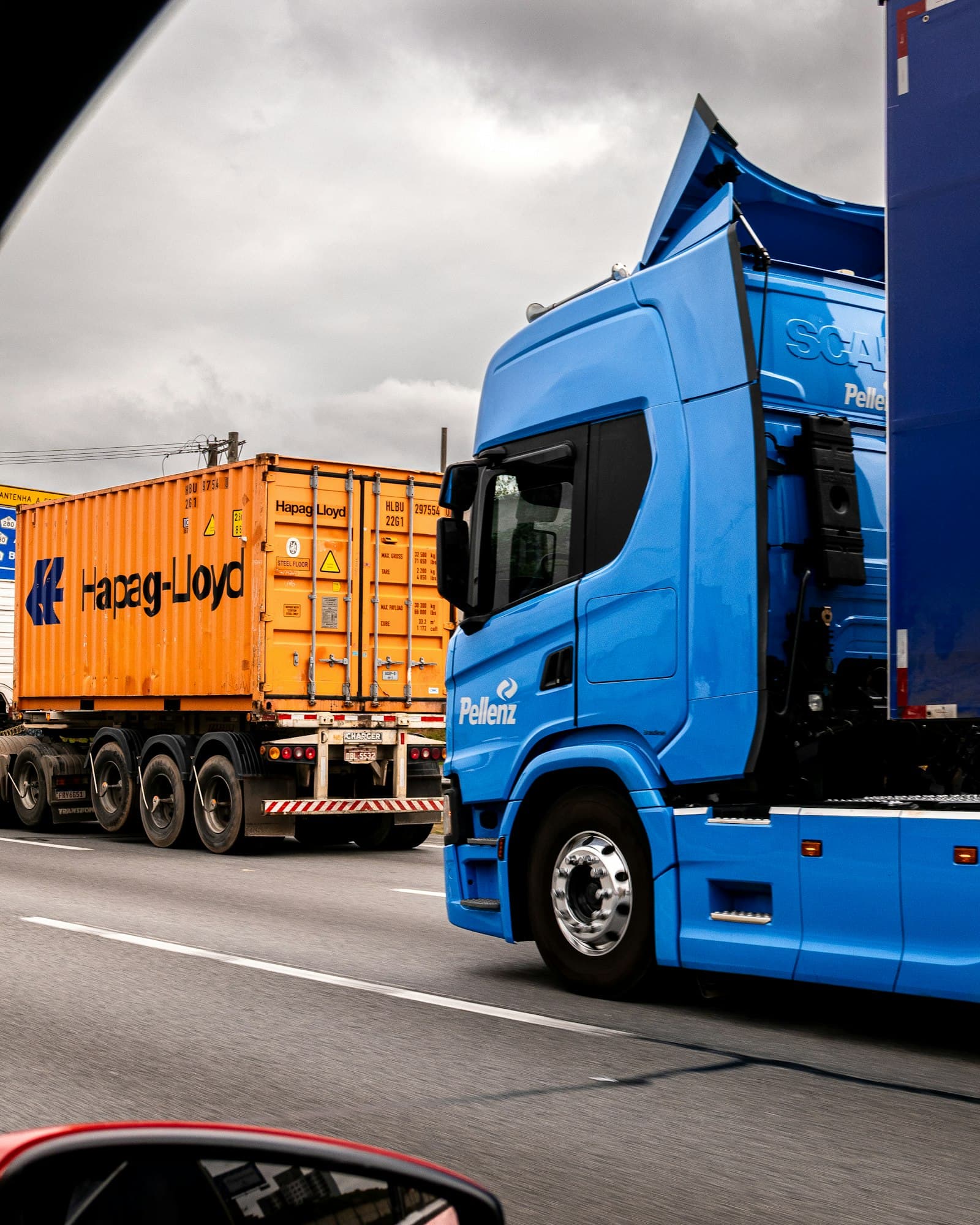 Blue semi truck with cargo trailer parked on a rural road