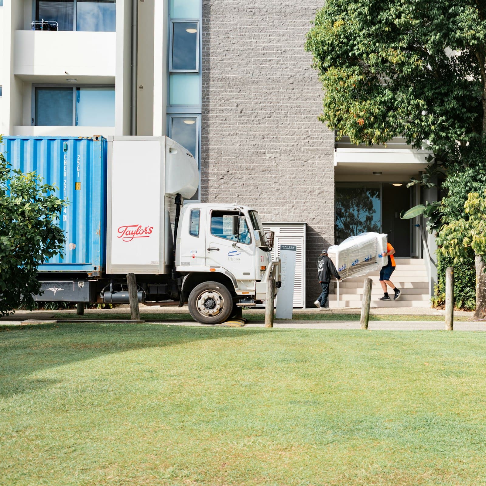 Delivery truck with workers unloading at a building