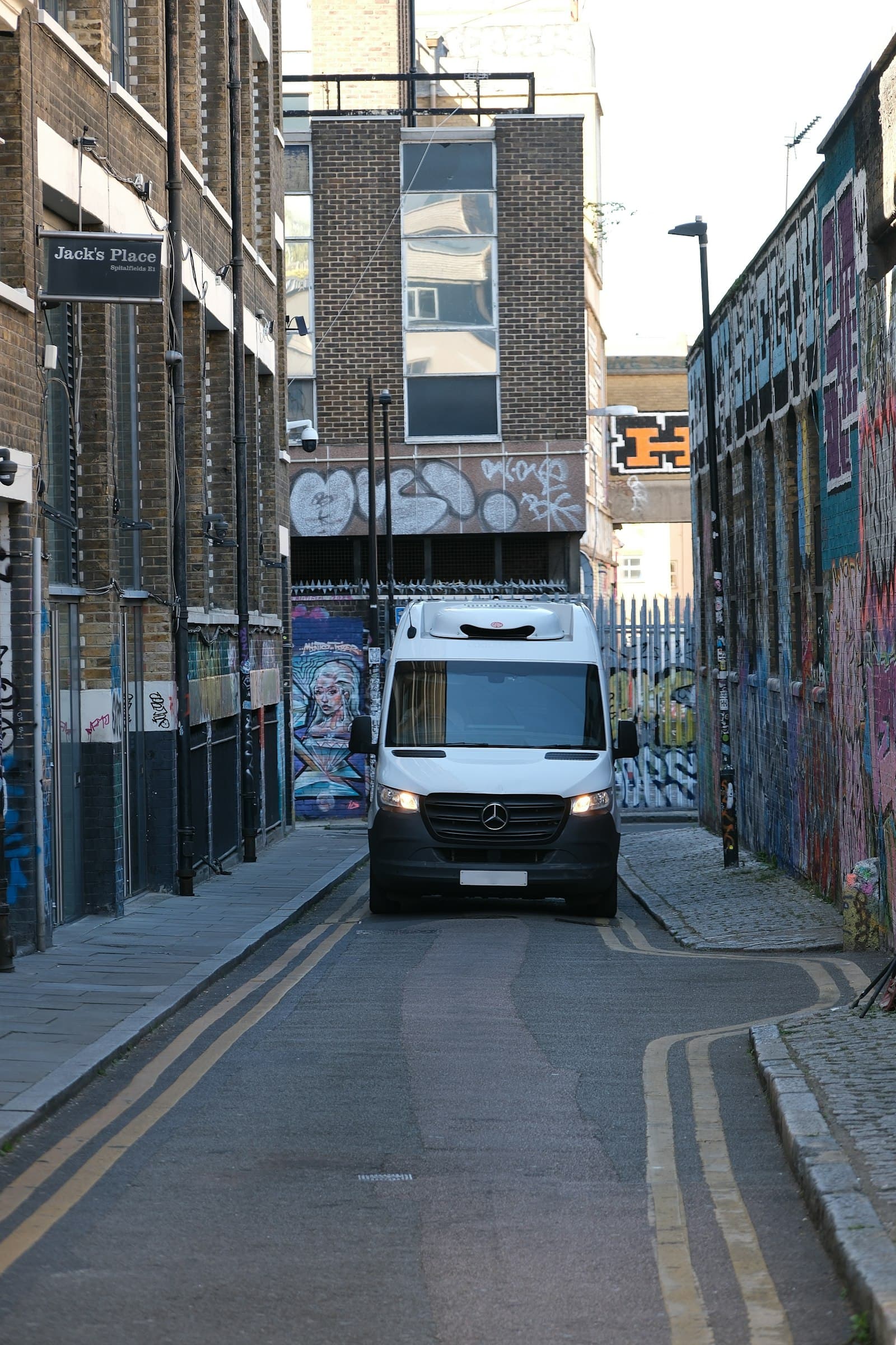 Delivery van driving down a narrow city street