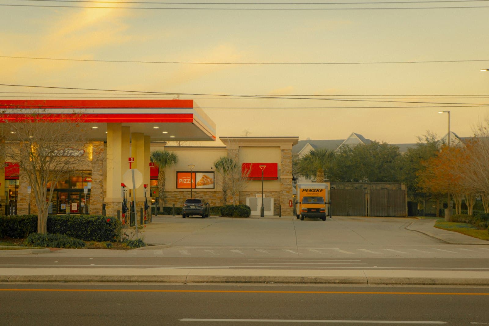 Gas station with trucks and cars parked at dusk