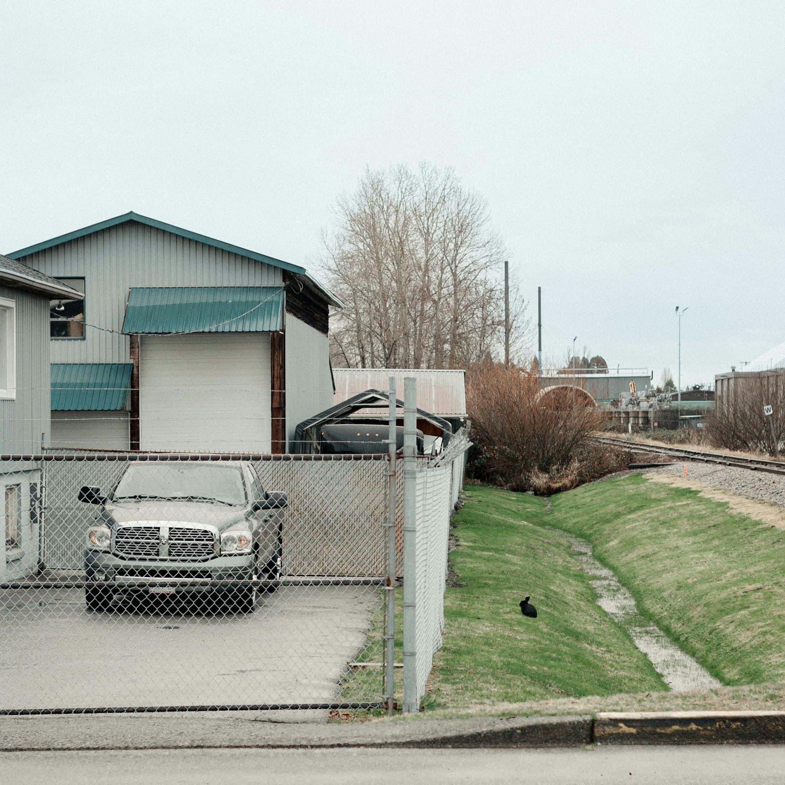 Truck parked in a fenced yard behind a warehouse