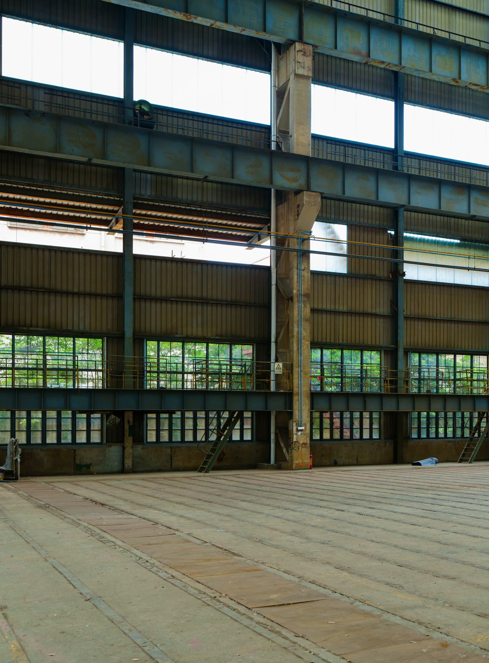 Large empty industrial warehouse with metal beams and windows