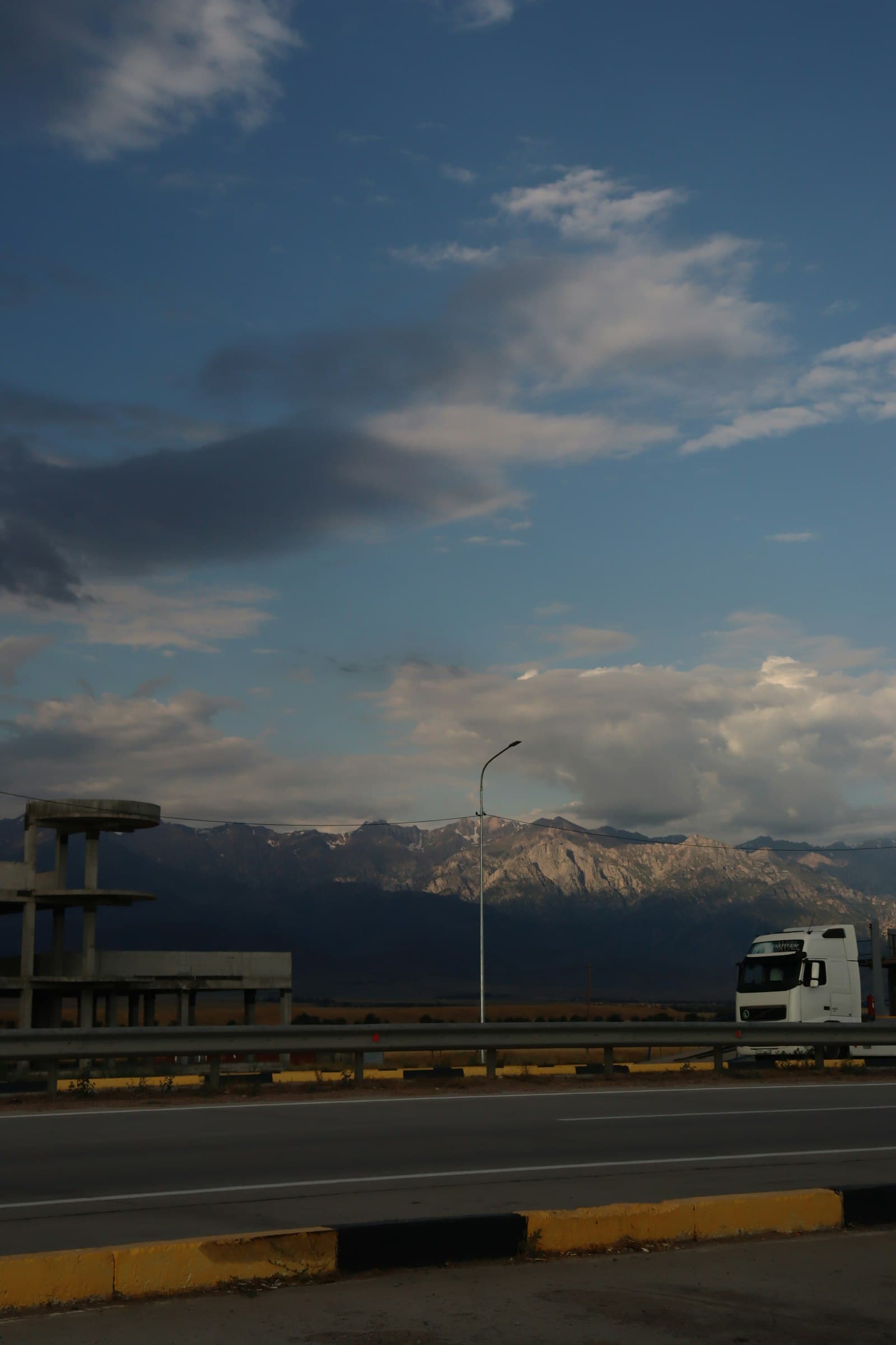 Truck driving on a highway with mountains in the background